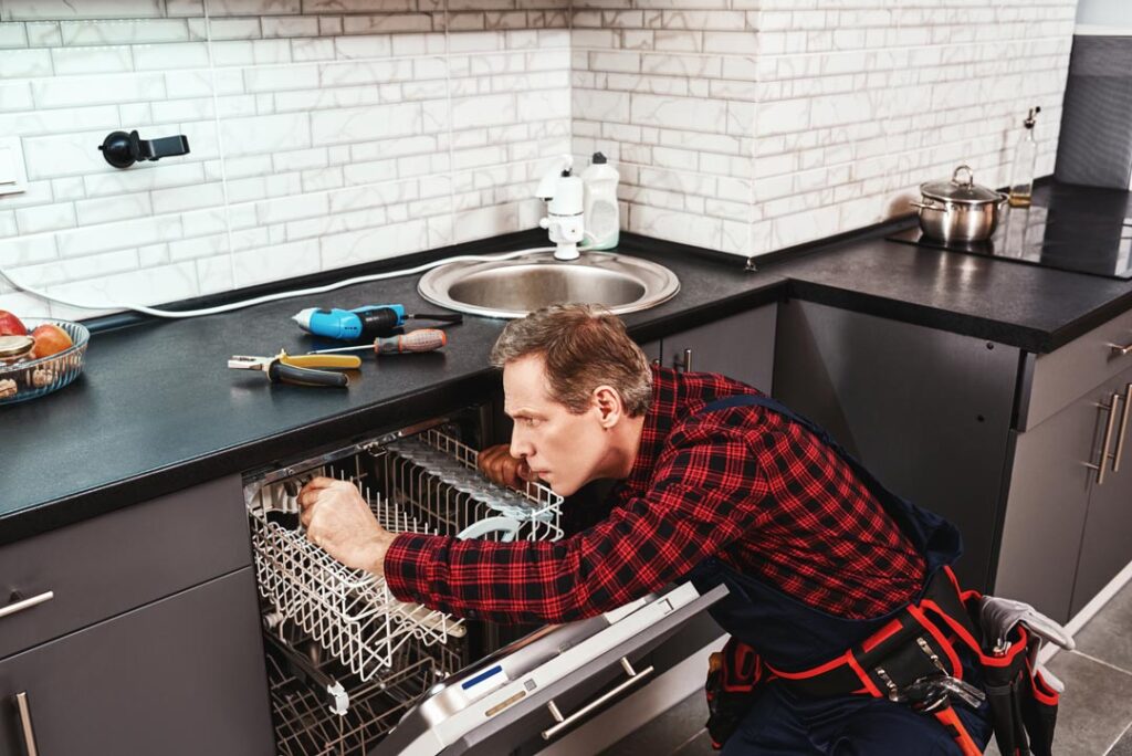 Side view of repairing dishwasher technician